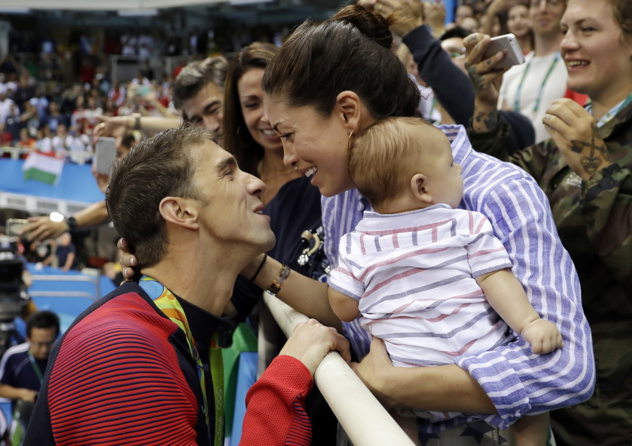 United States’ swimmer Michael Phelps celebrates winning his gold medal in the men’s 200-meter butterfly with his fiance Nicole Johnson and baby Boomer during the swimming competitions at the 2016 Summer Olympics in Rio de Janeiro, Brazil. Phelps says he has “no desire” to return to competitive swimming, but he’s eager to stay involved with the sport and cheer on those who follow in his enormous wake.