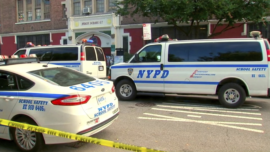 In this frame grab from video provided by WABC, police are gathered near the front door of Urban Assembly School for Wildlife Conservation in New York, Wednesday, Sept. 27, 2017. Police say a 15-year-old boy has been stabbed to death and a 16-year-old critically injured when they were attacked at the school which has middle and high school students attending.