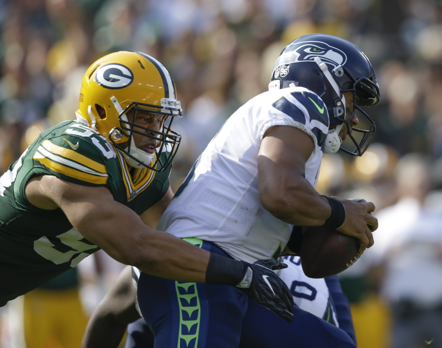 Green Bay’s Nick Perry sacks Seattle Seahawks’ Russell Wilson, who was given little time to throw throughout Sunday’s season-opening loss to the Packers.