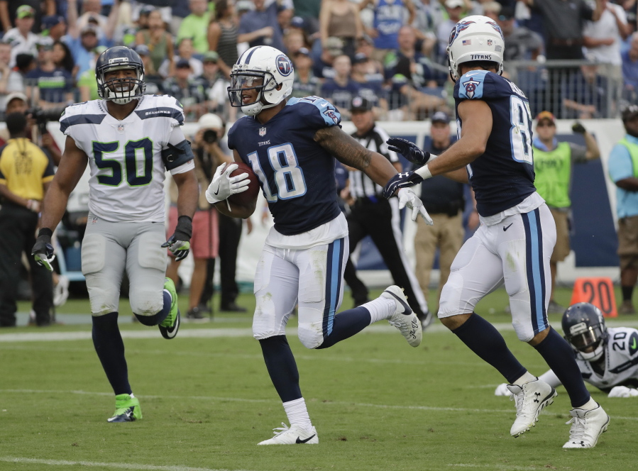 Tennessee Titans wide receiver Rishard Matthews (18) scores a touchdown on a 55-yard pass ahead of Seattle Seahawks outside linebacker K.J. Wright (50) in the second half of an NFL football game Sunday, Sept. 24, 2017, in Nashville, Tenn.