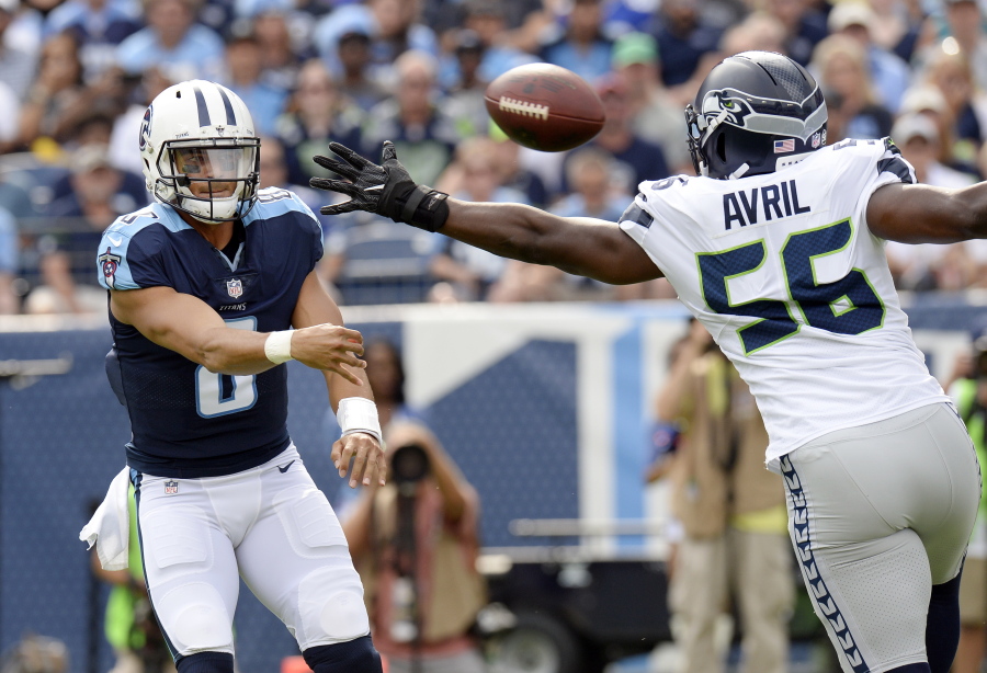 Tennessee Titans quarterback Marcus Mariota (8) passes past Seattle Seahawks defensive end Cliff Avril (56) in the first half of an NFL football game, Sunday, Sept. 24, 2017, in Nashville, Tenn.