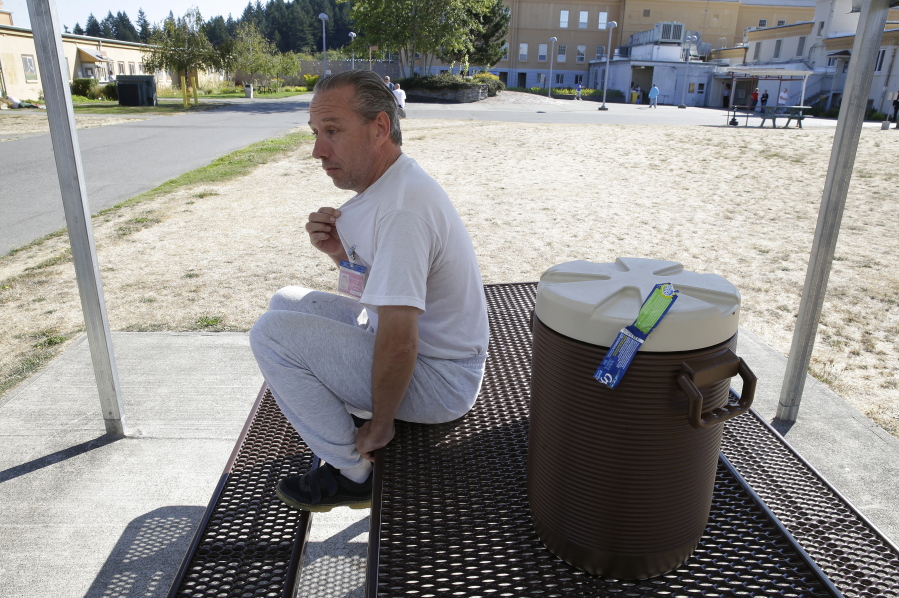 J.D. McManus, who has lived at the Special Commitment Center on McNeil Island since 2001, sits Sept. 15 next to a cooler of drinking water in a recreation yard and talks about how his shirts turn brown after being laundered at the facility. McManus also said he has suffered ill effects, such developing hives after taking a shower. Ted S.