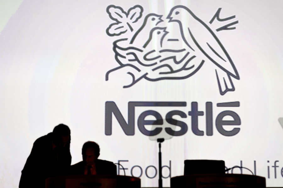 FILE - In this April 7, 2016 file photo Nestle’s directors speak in front of the Nestle’s logo during the general meeting of Nestle Group, in Lausanne, Switzerland. The world’s biggest food and drinks company, Nestle, says it is buying husband-and-wife startup Sweet Earth, which sells frozen burritos stuffed with quinoa, beans and other vegetarian ingredients. The Swiss company, whose frozen food brands include Lean Cuisine and Stouffer’s, said Thursday, Sept.