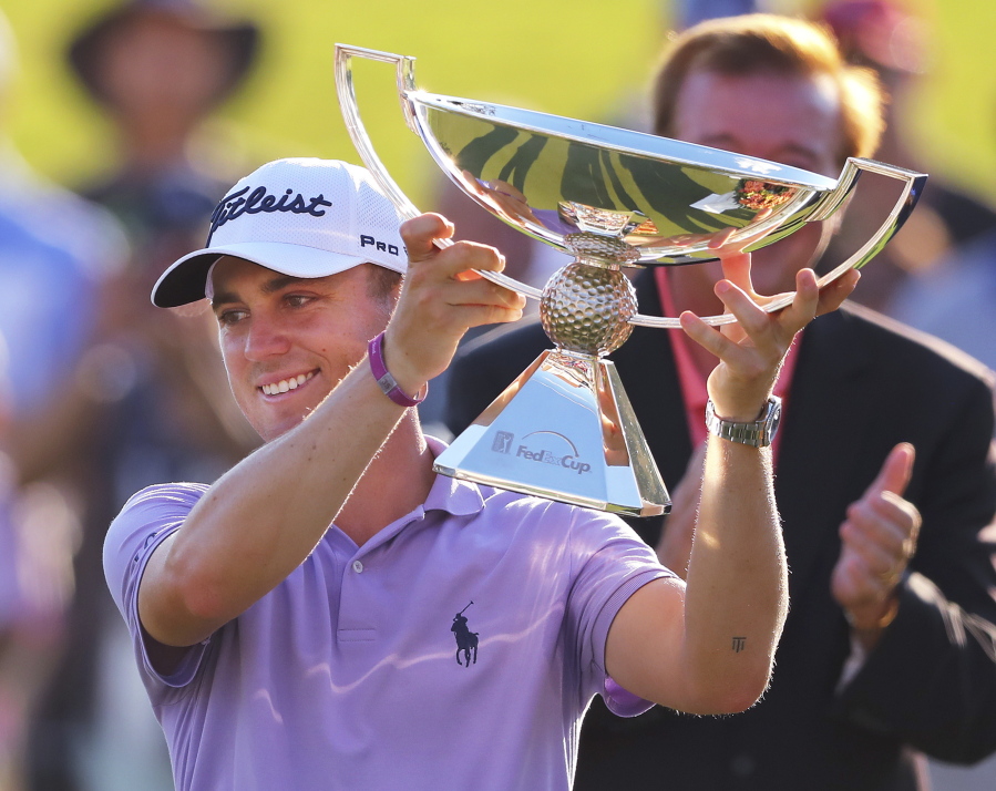 Justin Thomas holds the trophy after winning the Fedex Cup after the Tour Championship golf tournament at East Lake Golf Club in Atlanta, Sunday, Sept. 24, 2017, in Atlanta.