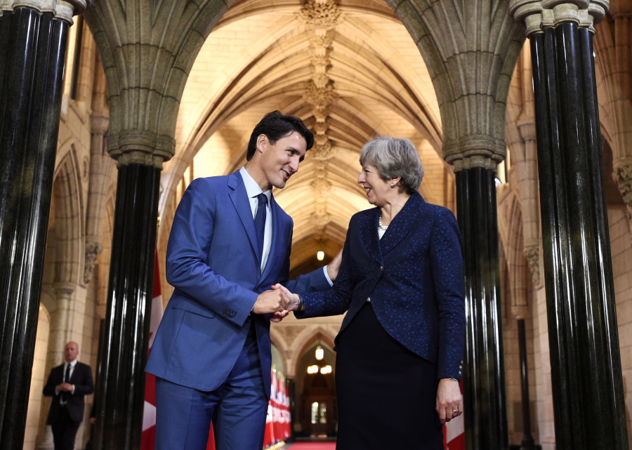 Prime Minister Justin Trudeau shakes hands with British Prime Minister Theresa May as she leaves Parliament Hill in Ottawa, Ontario, on Monday.