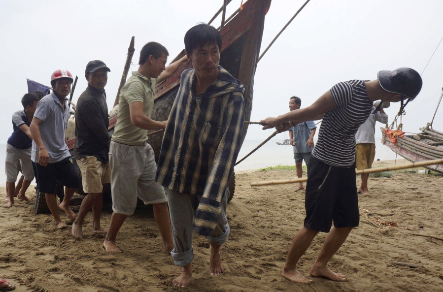 Vietnamese villagers move a fishing boat on shore in northern Thanh Hoa province, Vietnam, on Thursday. Vietnam on Thursday was bracing for typhoon Doksuri, which is expected to be the most powerful tropical cyclone to hit the Southeast Asian country in several years.