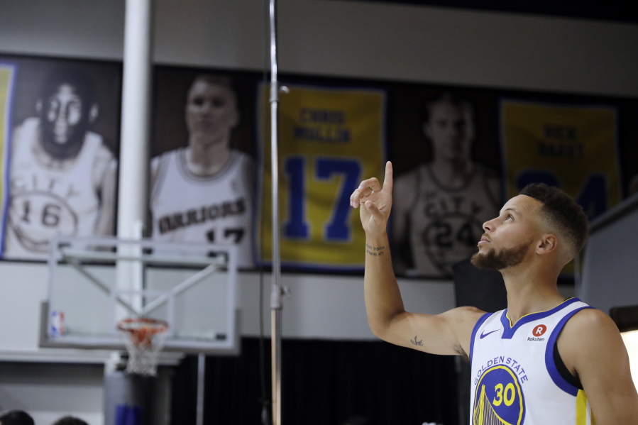 Golden State Warriors’ Stephen Curry poses for photos during NBA basketball team media day Friday, Sept. 22, 2017, in Oakland, Calif.