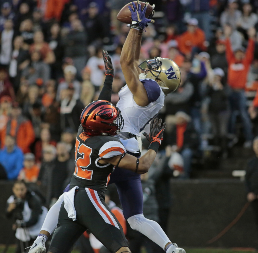 Washington wide receiver Dante Pettis (8) goes high over Oregon State’s Isaiah Dunn (22) for a touchdown in the second half of an NCAA college football game, in Corvallis, Ore., Saturday, Sept. 30, 2017. Washington won 42-7. (AP Photo/Timothy J.