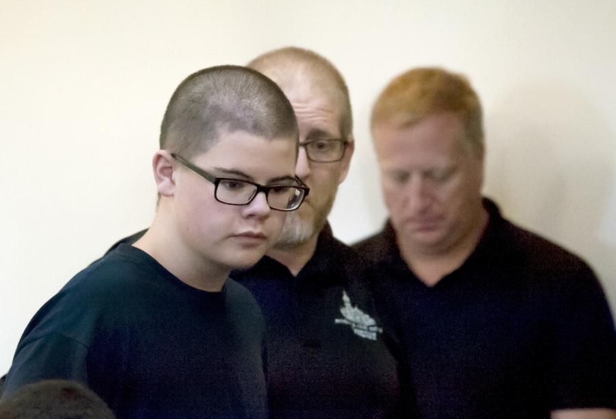 Caleb Sharpe walks into Spokane County Juvenile Court to a packed courtroom on Wednesday, Sept. 27, 2017, in Spokane, Wash. A hearing to determine whether the 15-year-old boy will be tried as an adult on charges he fatally shot a classmate and wounded three others at his rural Washington state high school will not occur until next spring, a judge said Wednesday.