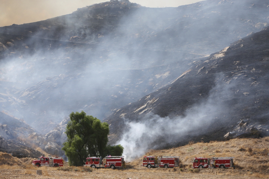 The Marlborough fire races up a hill from where it started on Thursday in Riverside, Calif.