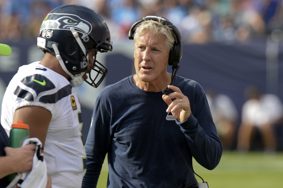 FILE - In this Sept. 24, 2017, file photo, Seattle Seahawks head coach Pete Carroll talks with quarterback Russell Wilson in the first half of an NFL football game against the Tennessee Titans in Nashville, Tenn.