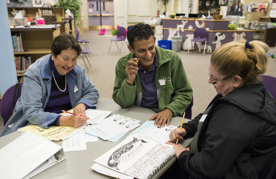 Clarita Manrique, from left, originally from Colombia, Ali Alquraisha, a volunteer originally from Kuwait, and Fidelina Ayala, originally from Mexico, work through exercises in an English class offered at Hathaway Elementary School through a partnership between the Washougal School District and Clark College.