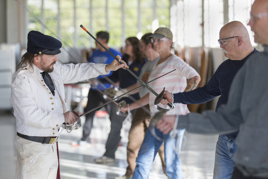 Instructor Jeff Richardson from Academia Duellatoria, left, checks Herb Maxey’s posture during a saber training course at Pearson Air Museum on Sunday.