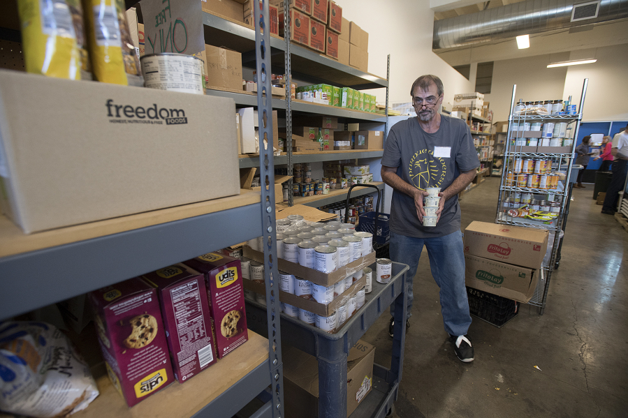 Volunteer John Kaloudis sorts donated food while helping to clients at Friends in Service to Humanity Westside Food Pantry of Vancouver, otherwise known as FISH.