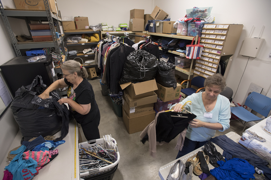 Volunteers Vickie Neal, left, and Diane Kessell sort through donated clothes at Friends in Service to Humanity Westside Food Pantry of Vancouver, otherwise known as FISH. Kessell said they are always in need of clothing donations, especially men’s clothes.
