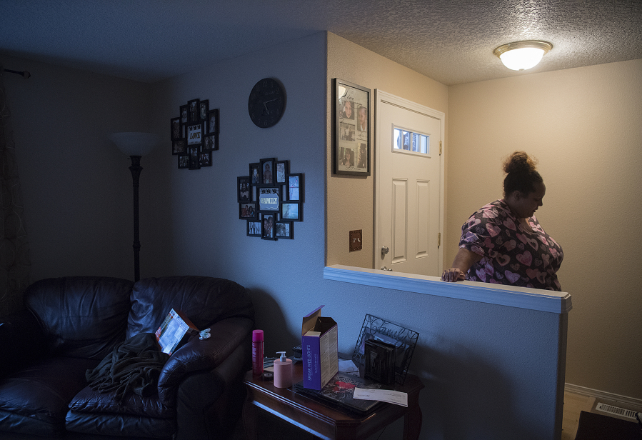 Vancouver resident Charmaine Crossley pauses in the front hallway of her rental home while helping her son prepare for football practice Wednesday. Crossley is facing possible eviction.