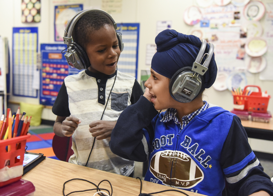 Benaiah Toussaint, 6, from Haiti and Amritpal Singh, 6, from India, sing together while working on iPads in their English language learning class for first through third grades in the Fircrest Elementary School Newcomers Program on Tuesday. Students learn English and about the United States’ culture while enrolled in the program.