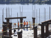 Rotschy Inc. employees work together on the edge of the Grant Street Pier at The Waterfront Vancouver. The pier, owned by the city of Vancouver, could be completed by February, according to Gramor Development.