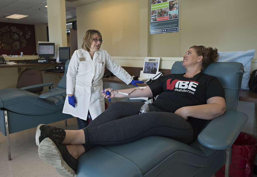 Julie Burrell of Bloodworks Northwest, left, chats with Vancouver resident Darcy Urdesich as she donates blood in October at the Vancouver Donor Center.