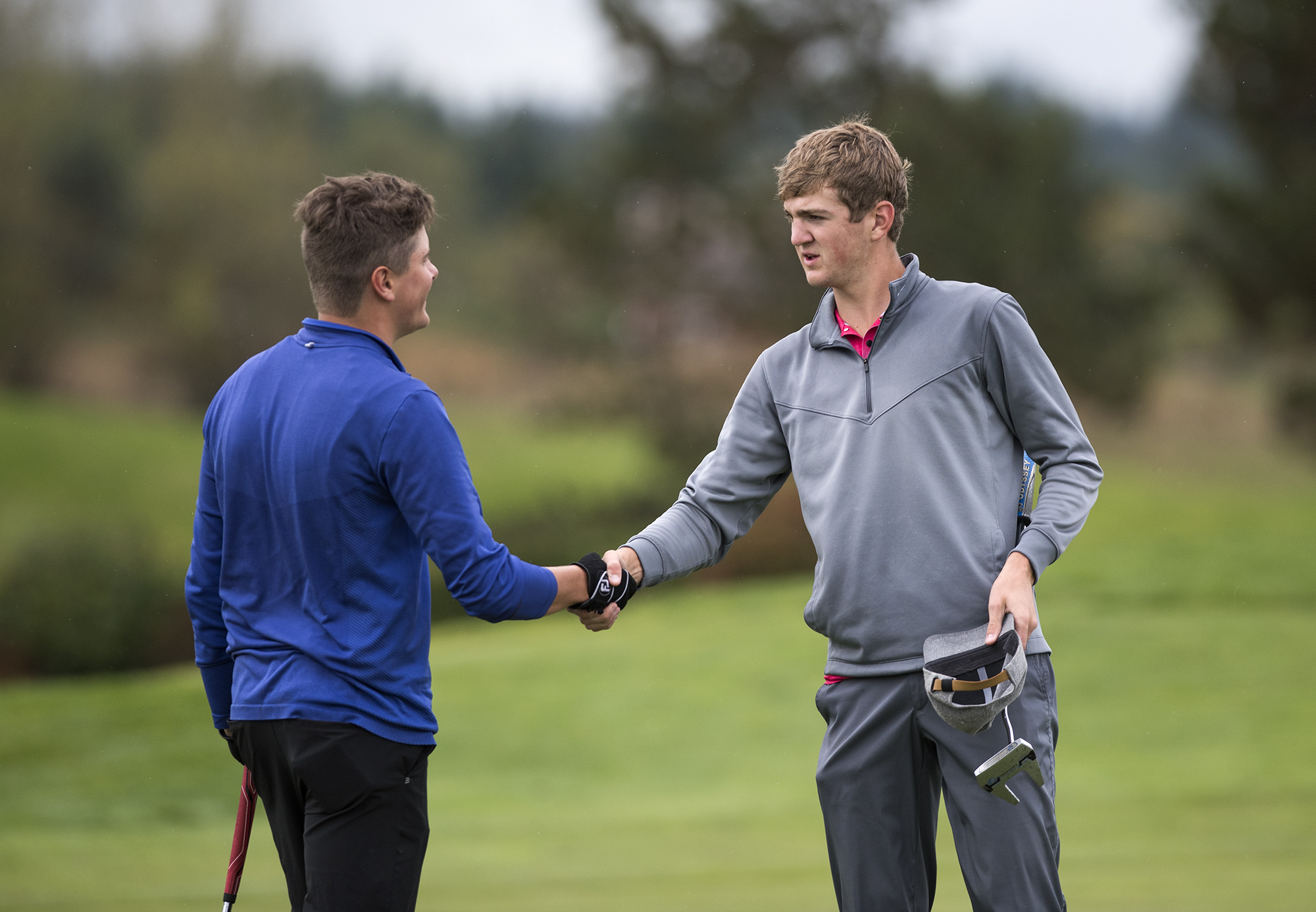 Mountain View's Mason White, left, and Prairie's Dante Heitschmidt shake hands after the 3A district golf tournament at Tri-Mountain in Ridgefield Tuesday afternoon, Oct. 10, 2017.