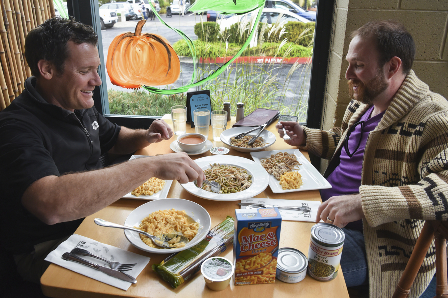 Mayor Tim Leavitt, left, serves himself whole-wheat pasta, tuna fish and peas at lunch Tuesday with Share volunteer Kenny Dunn at Beaches Restaurant. The meal was created using items from backpack food distributed to local low-income students.