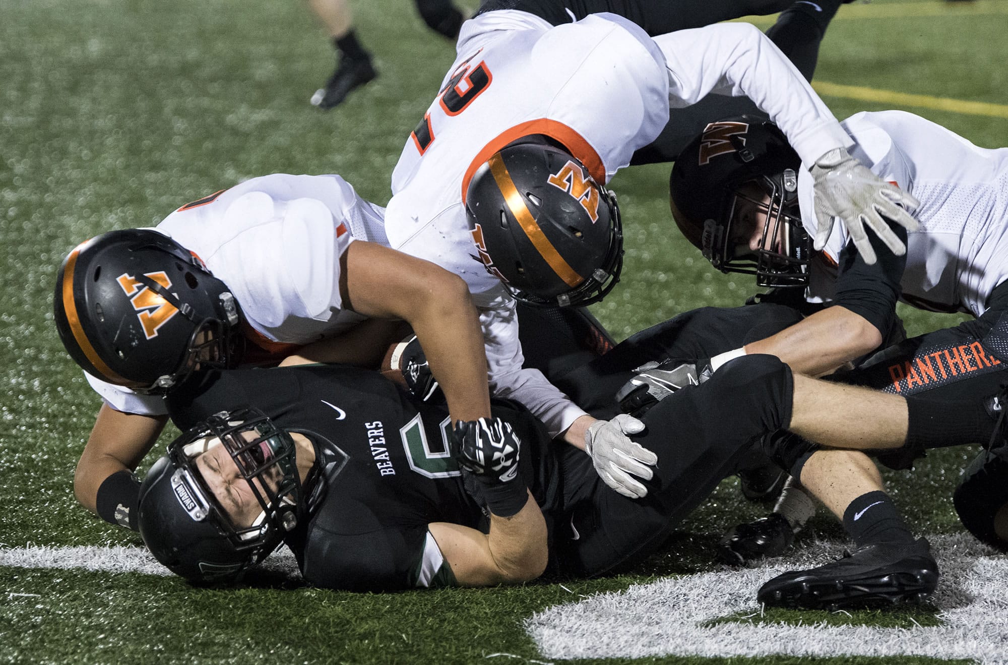 Woodland's Christian Yager (6) is taken down by Washougal's Brenden Brock (51), Gus Shelley (31) and Dalton Payne (9) during Friday night's game at Woodland High School on Oct. 13, 2017. Woodland defeated Washougal 20-7.