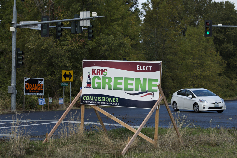 A motorist passes campaign signs for Port of Vancouver District 1 candidates Kris Green, foreground, and Don Orange at the intersection of Northwest 78th Street and Northwest Lakeshore Avenue on Wednesday morning.