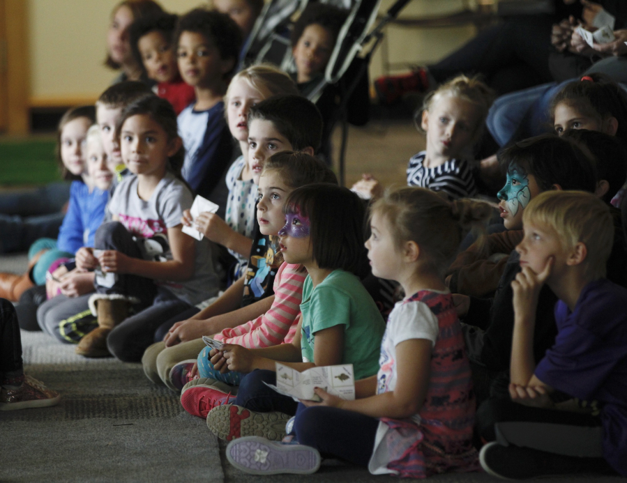 Children listen and watch a presentation about owls, hawks and other birds of prey Sunday at the Vancouver Water Resources Education Center.