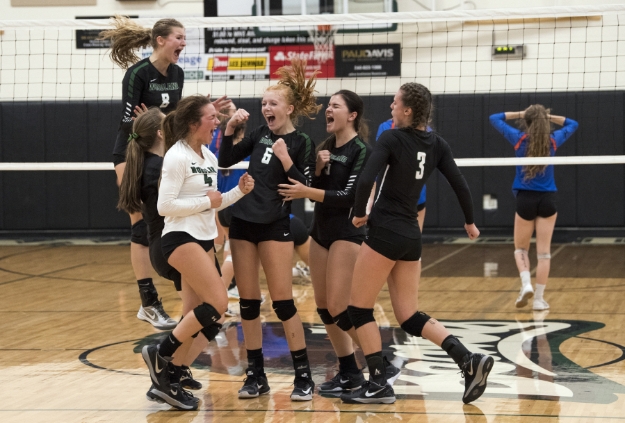 Woodland celebrates winning the fourth set and match against Ridgefield on Thursday, earning the top seed for the upcoming district tournament.