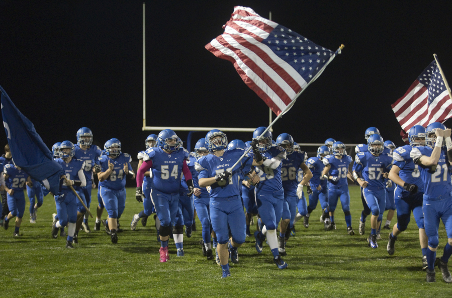 The La Center Wildcats enter the field carrying the United States national flag at a football game in La Center Friday October 20, 2017.