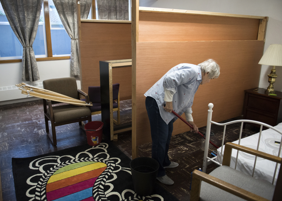 Mary Ellen Sandberg cleans out a room in the basement of St. Luke’s Episcopal Church, which was being prepped Thursday to become a shelter for homeless women.