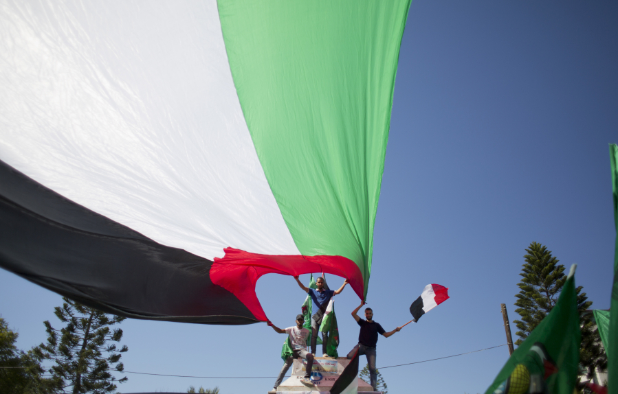 Palestinians wave national and Egyptian flags to celebrate the preliminary reconciliation agreement between Hamas and Fatah on Thursday in Gaza City.