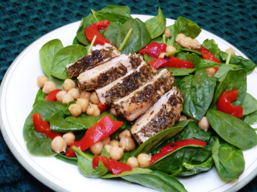Tender chicken coated with French herbes de Provence and served over a bed of baby spinach salad is a simple and fast dish.