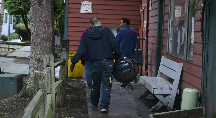 Property management staff clear remaining possessions from tenant patios at the Courtyard Village apartment complex in Vancouver in 2014. Because of new ownership and planned renovations, many tenants were given notices to vacate.