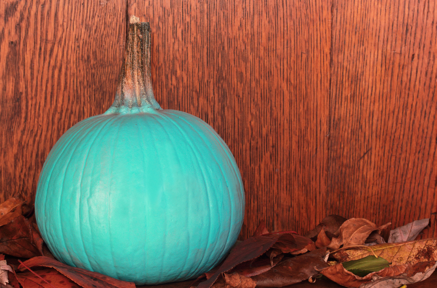 A teal pumpkin on a porch signals allergy-friendly or non-food treats, part of the Teal Pumpkin Project.