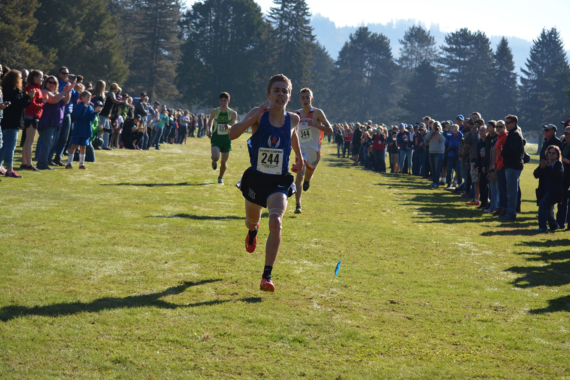 Kyle Radosevich of Ridgefield kicks to the finish line to win the 2A district cross country title on Saturday, Oct. 28, 2017, at Lewis River Golf Course in Woodland.