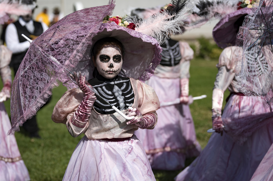 A group of young girls take part in the Dia de los Muertos (Day of the Dead) festivities at the Hollywood Forever Cemetery on Saturday in Los Angeles. Day of the Dead has its origin in Mexico and is widely celebrated by Mexican-Americans as a tribute to the lives of loved ones who passed away.