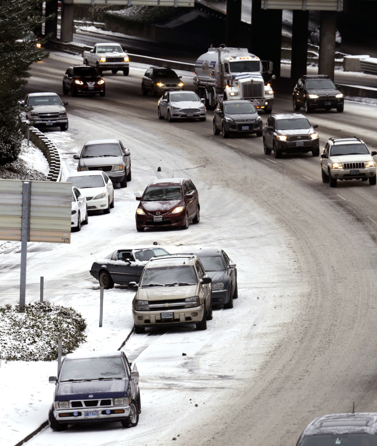 Abandoned cars line the side of I-405 in December as commuters work their way into town in Portland. A winter storm dumped several inches of snow in the area late Wednesday, snarling traffic, causing many commuters to abandon their cars.