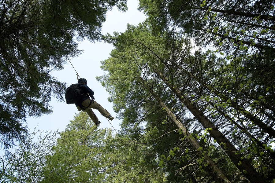 Adam Lapierre, a photographer for Gorge Magazine in Hood River, rides the zip line under a canopy at Skamania Lodge in Stevenson.