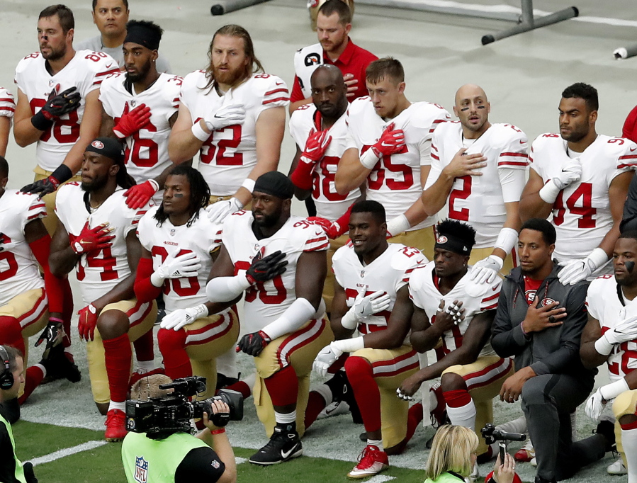 Members of the San Francisco 49ers kneel during the national anthem as others stand prior to an NFL football game against the Arizona Cardinals, Sunday, Oct. 1, 2017, in Glendale, Ariz.