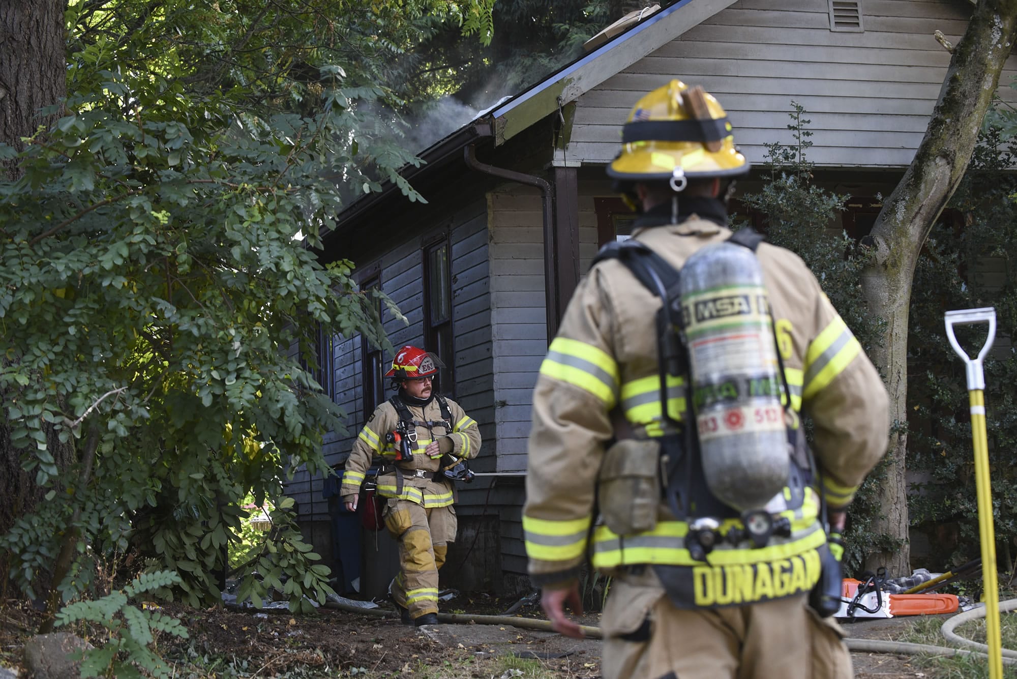 A firefighter emerges from the back of a home that caught fire in the Hough Neighborhood, Monday afternoon, October 9, 2017.
