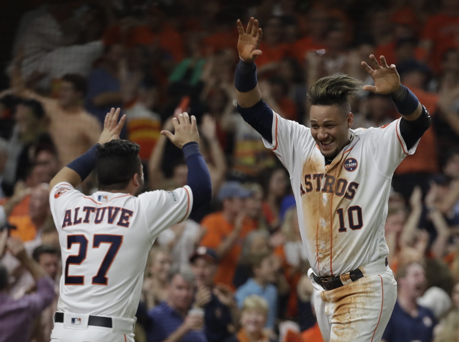 Houston Astros’ Yuli Gurriel is congratulated by Jose Altuve after scoring during the fifth inning of Game 7 of baseball’s American League Championship Series against the New York Yankees Saturday, Oct. 21, 2017, in Houston. (AP Photo/David J.