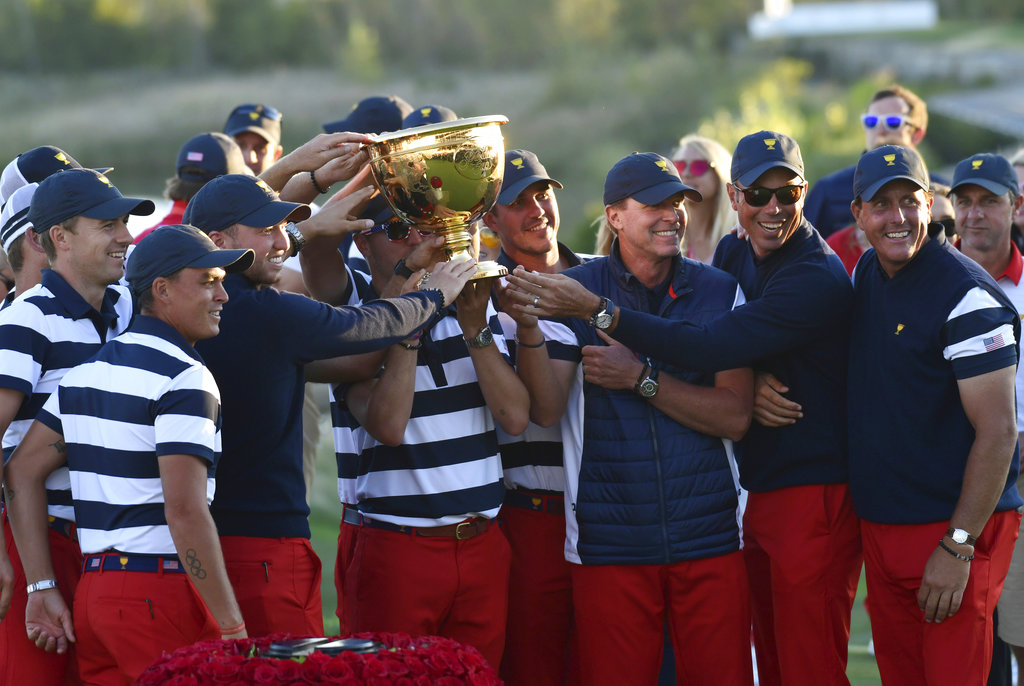 The U.S. Team celebrates with the winner's trophy after the final round of the Presidents Cup golf tournament at Liberty National Golf Club in Jersey City, N.J., Sunday, Oct. 1, 2017.