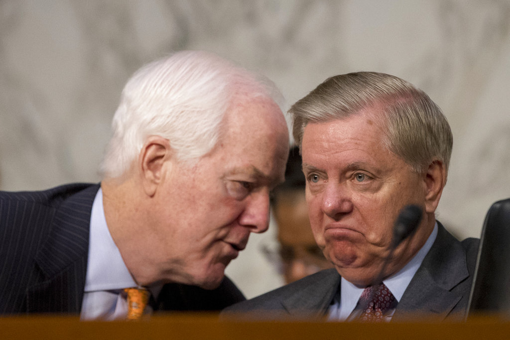 Senate Majority Whip Sen. John Cornyn, R-Texas., left, speaks with Sen. Lindsey Graham, R-S.C., right, during a Senate Judiciary Committee hearing on Capitol Hill in Washington, Tuesday, Oct. 3, 2017, on the Trump Administration's decision to end Deferred Action for Childhood Arrivals otherwise known as DACA.