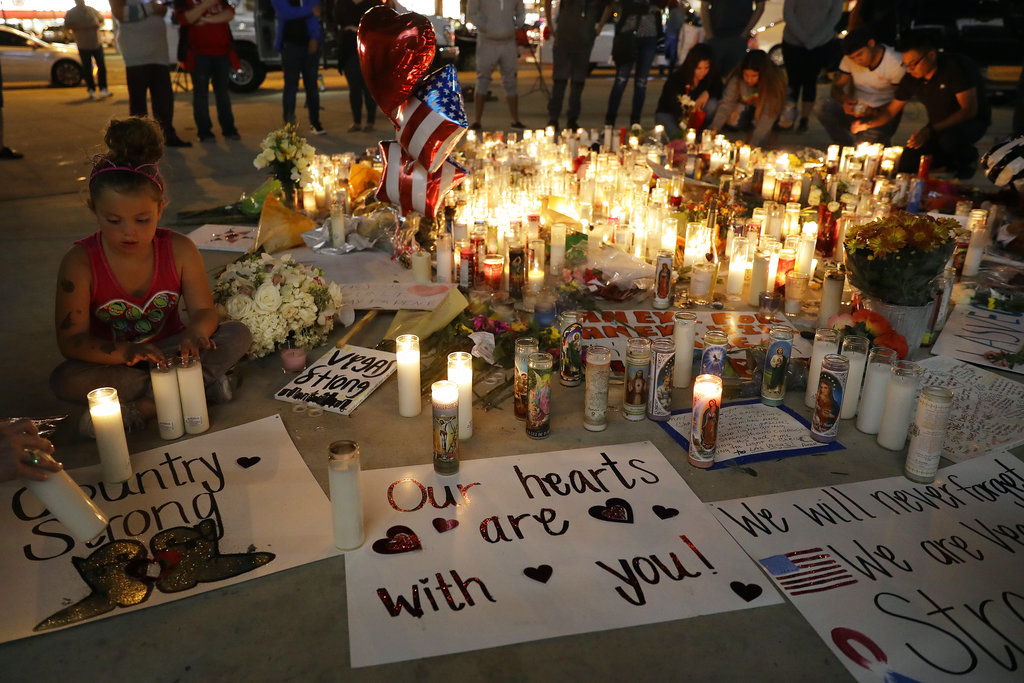 A girl places candles at a memorial for victims of the mass shooting Tuesday, Oct. 3, 2017, in Las Vegas. A gunman opened fire on an outdoor music concert on Sunday. It was the deadliest mass shooting in modern U.S. history, with dozens killed and hundreds injured, some by gunfire, some during the chaotic escape.