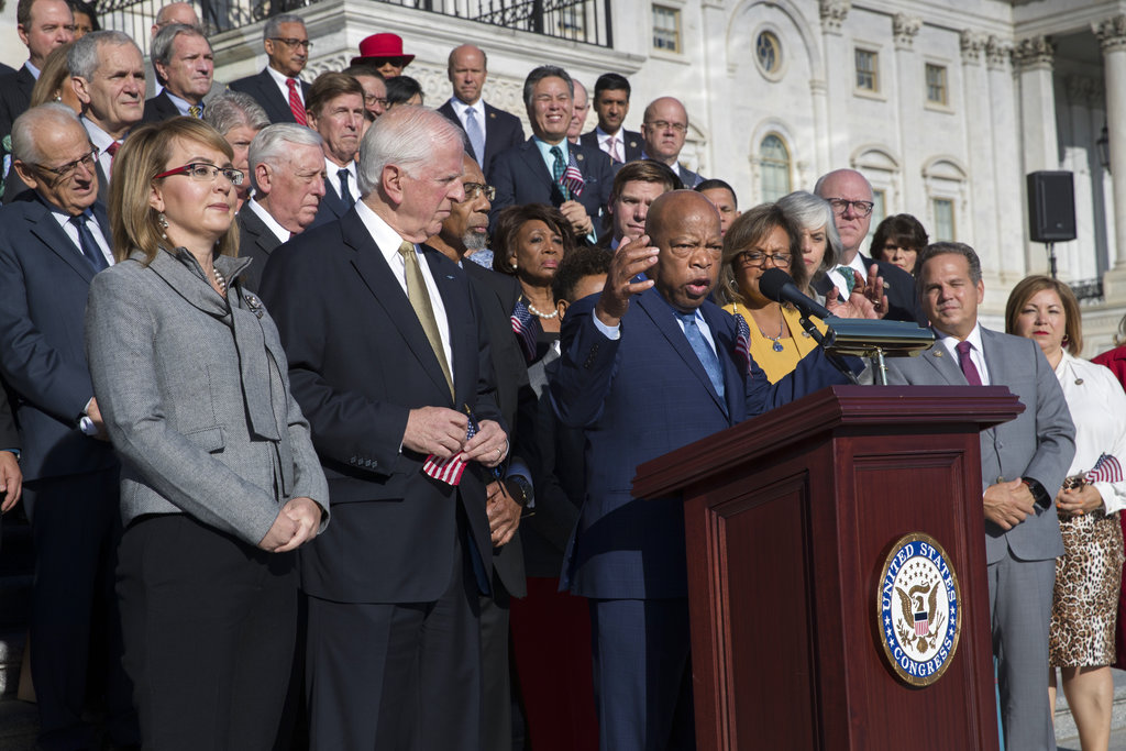 Civil rights leader Rep. John Lewis, D-Ga., speaking, joined by, from left, former Rep. Gabby Giffords of Arizona, and Rep. Mike Thompson, D-Calif., call for action on gun safety legislation with fellow Democrats on the House steps Wednesday morning after the deadly mass shooting in Las Vegas this week, at the Capitol in Washington, Wednesday, Oct. 4, 2017. Giffords survived an assassination attempt in 2011 while speaking to constituents in Tucson. (AP Photo/J.