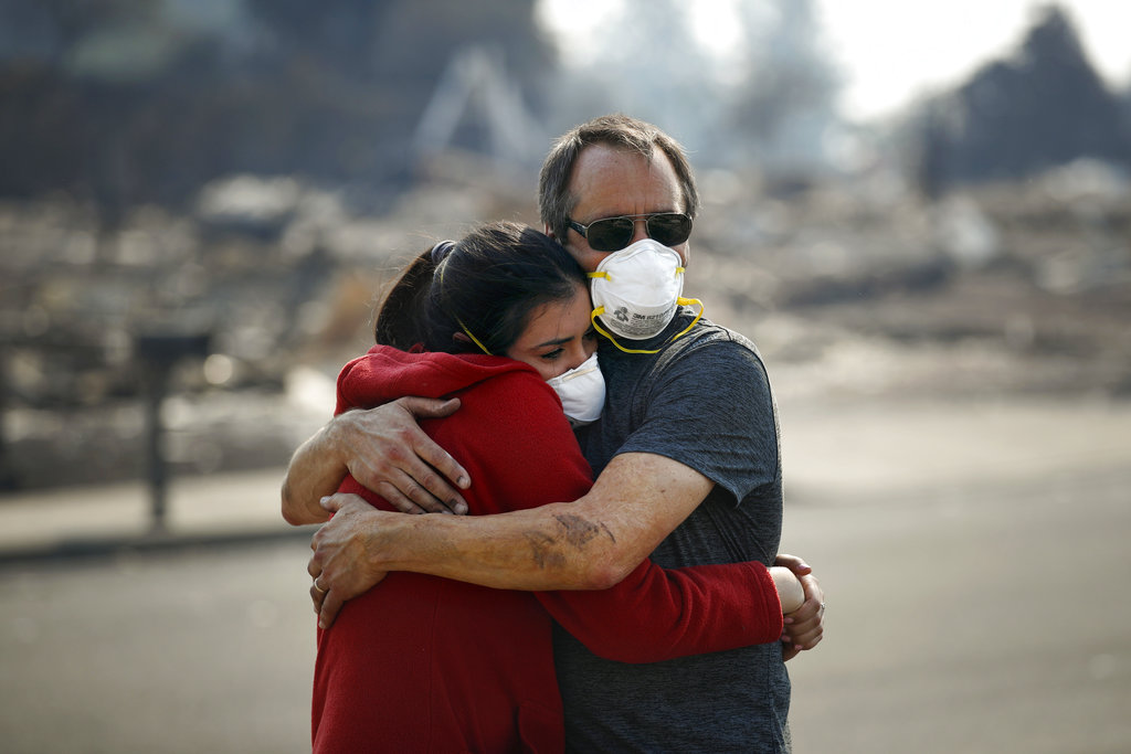 Howard Lasker, right, comforts his daughter, Gabrielle, who is visiting their home for the first time since a wildfire swept through it Sunday, Oct. 15, 2017, in Santa Rosa, Calif. With the winds dying down, fire officials said Sunday they have apparently "turned a corner" against the wildfires that have devastated California wine country and other parts of the state over the past week, and thousands of people got the all-clear to return home. (AP Photo/Jae C.