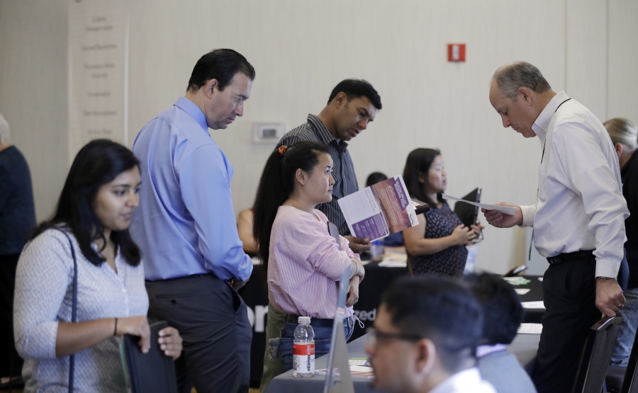 Phil Wiggett, right, a recruiter with the Silicon Valley Community Foundation, looks at a resume during a job fair in San Jose, Calif. On Friday, Oct. 6, 2017, the U.S. government issues the September jobs report.