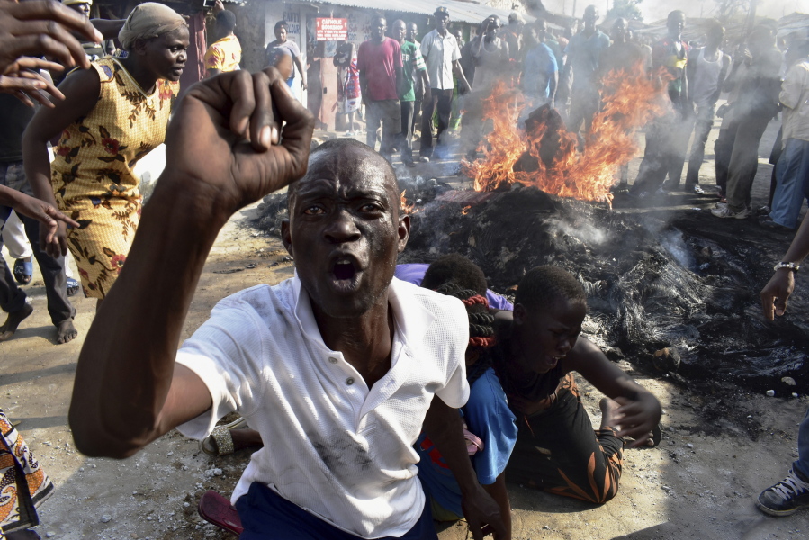 A opposition supporter reacts after burning tyres during demonstrations in Mombasa, Kenya, on Thursday. Kenya is holding the rerun of its disputed presidential election Thursday, despite a boycott by the main opposition party and rising political tensions in the East African country.