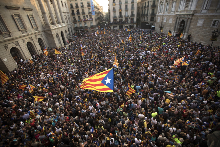 People wave pro-independence flags outside the Palau Generalitat on Friday in Barcelona, Spain, after Catalonia’s regional parliament passed a motion with which they say they are establishing an independent Catalan Republic.